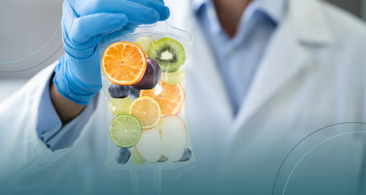 Conceptual image of a gloved hand holding an IV bag filled with fruit slices