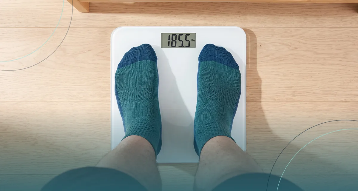 Feet in teal socks standing on a bathroom scale