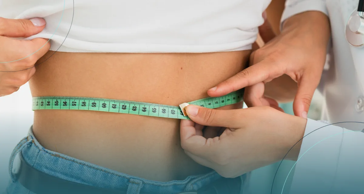 Clinician measuring a patient's waist with a tape measure