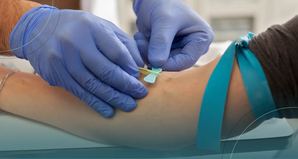 Gloved clinician placing a butterfly needle for a blood draw with a teal tourniquet